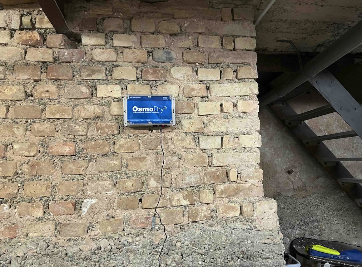 Boîtier OsmoDry installé sur mur en brique